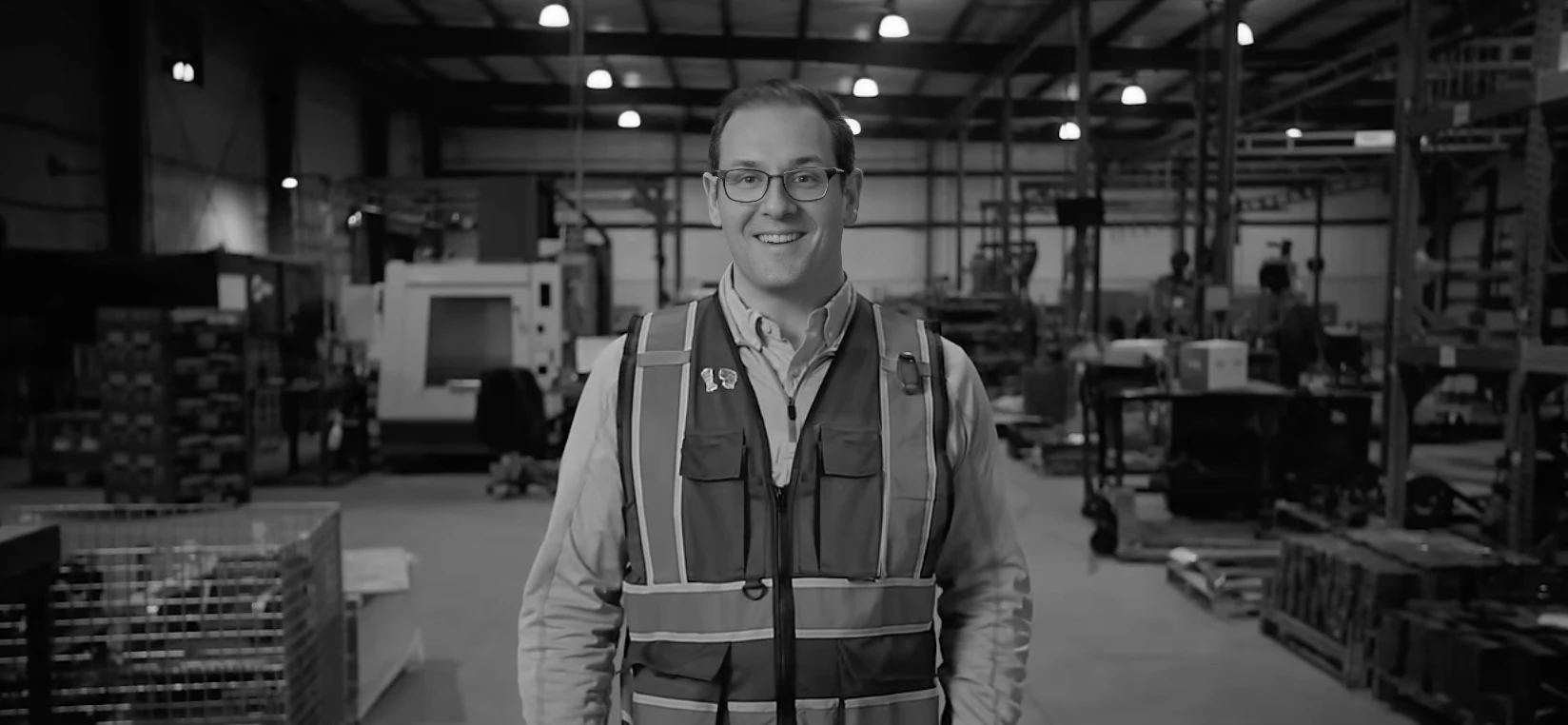 Jonathan Weiss in a hi-vis vest on a manufacturing floor